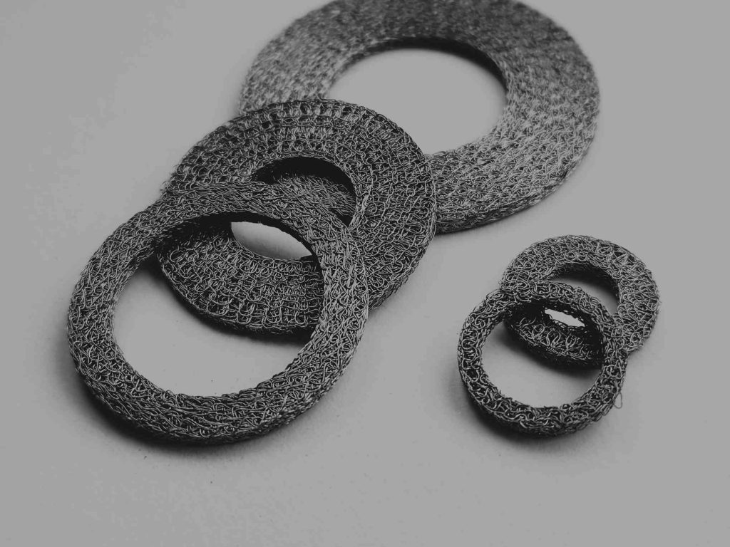 Compressed round mesh for EMI/RFI shielding, providing reliable conductivity and sealing in electronic enclosures and connectors.